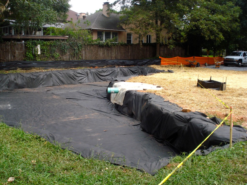 This photo shows the bio-retention pond and the pipe (green) that will carry water to it from the adjacent intake (surrounded by silt fencing).