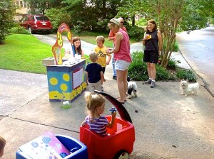 A crowd gathers at Bennett Kane’s colorful lemonade stand on Brookridge Dr. near Orme Park. Bennett (yellow t-shirt) takes an order from resident Kim Terry and her children while Tommy Manning, Victoria Talley and Elizabeth Shipp look on.